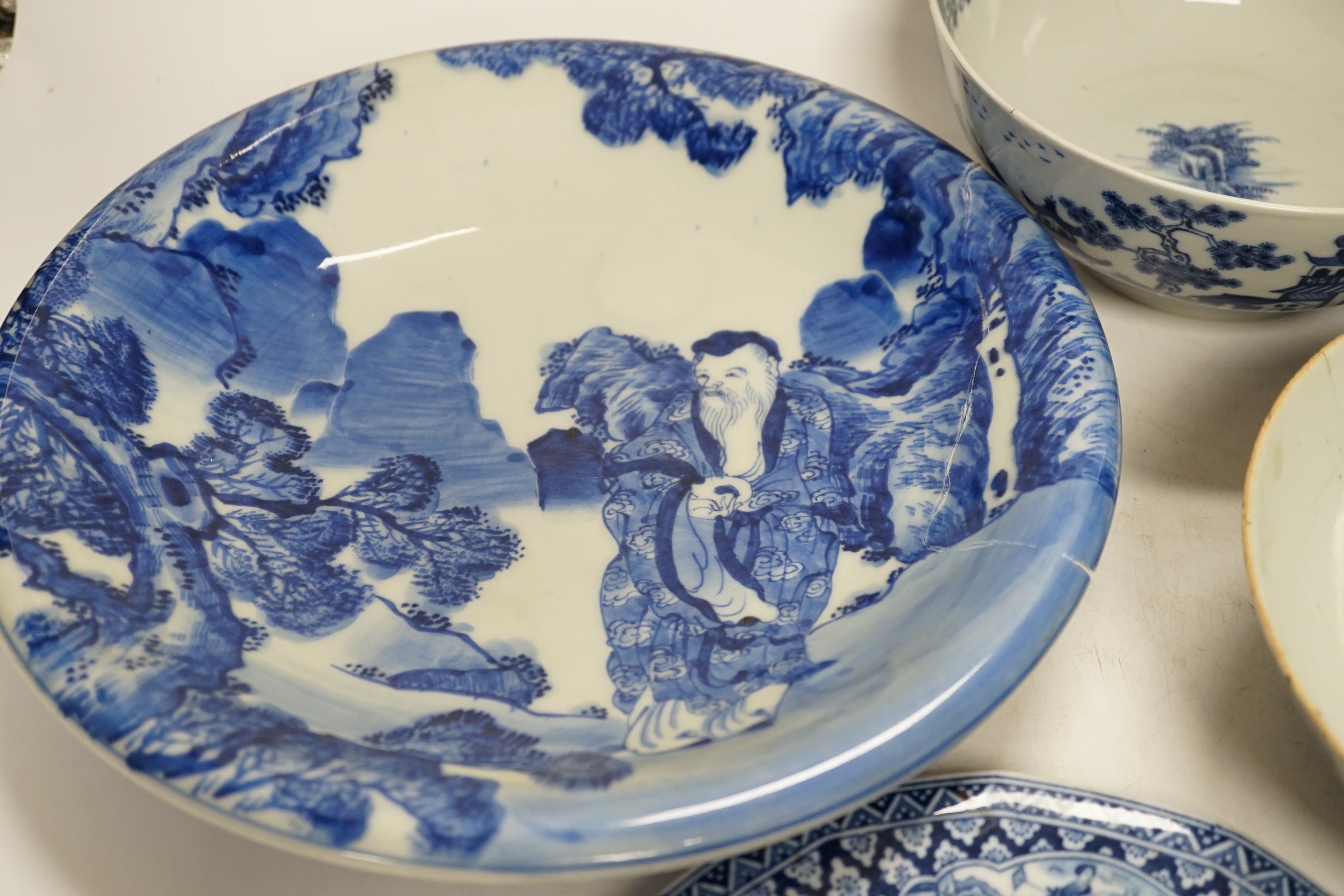Assorted Chinese and Japanese ceramics comprising a famille rose bowl, two blue and white plates and a blue and white bowl, largest 30cm in diameter